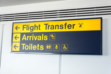 Black and yellow flight transfer, arrivals and toilets sign