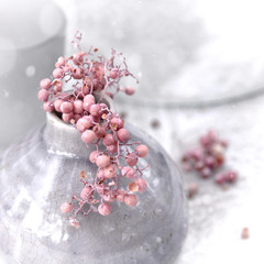 snow on blush pink berries in grey vase 