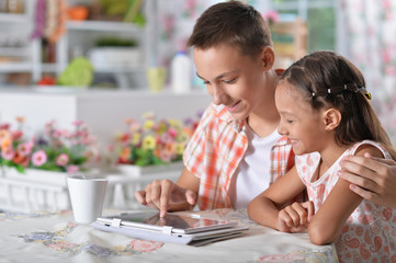 Obraz premium Brother and sister using tablet