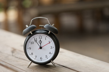 Naklejka premium Retro alarm clock with five minutes to twelve o'clock.