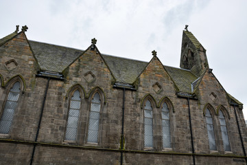 Fototapeta na wymiar Old medieval Scottish stone church with clouds