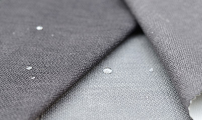 Close up water drop on grey gunny textile. Concept for easy clean, waterproof surfaces