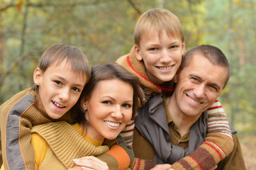 smiling family in autumn forest 