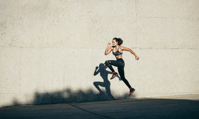Healthy woman running and jumping outdoors © Jacob Lund
