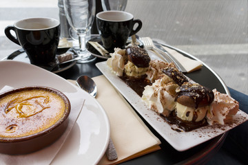 Coffee and hot desserts  on rainy day in outdoor cafe. Selective focus.