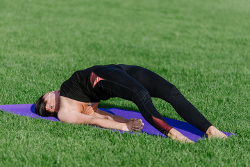 Fototapeta premium young woman doing yoga in the park in the morning in autumn.