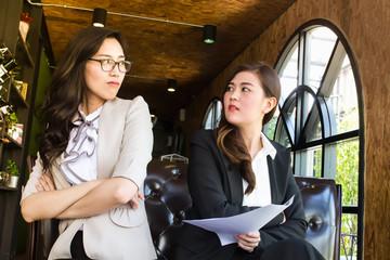 Two beautiful business woman, looking against with feel repulsion. .Business concept.