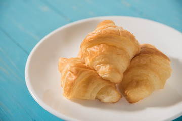 croissant in white plate on wood table