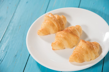 croissant in white plate on wood table