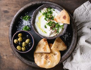 labneh middle eastern lebanese cream cheese dip with olive oil, salt, herbs served with olives,...
