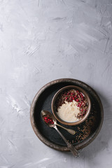 Bowl of milk cereal porridge with additives flax seeds, chocolate and berries over gray texture background. Top view with space