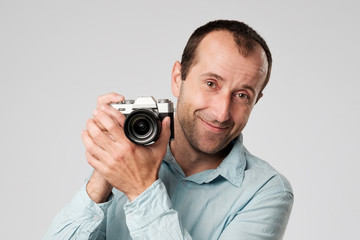 Fototapeta premium Mature caucasian man in blue t-shirt studing to use digital camera