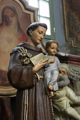 Fototapeta na wymiar Saint Anthony of Padua holding baby Jesus statue with lily flower, church in Wroclaw