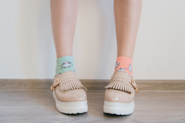 Naked women`s feet in feminine business bright leather shoes with tankette and white sole standing...