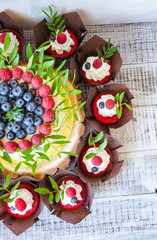 Fototapeta na wymiar berry wedding cake and red velvet cupcakes