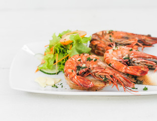 Prawn dish on the toasted bread with salad and garlic 