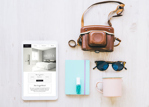 Travel Essentials And Hotel Website On Tablet