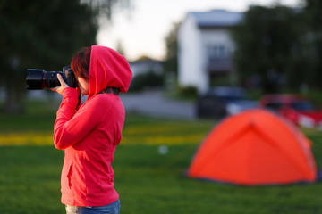 Girl photographer near of tent camp