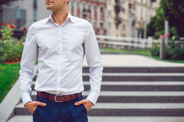 Young male businessman in shirt and blue pants. Hands in pockets. Hotizontal mockup