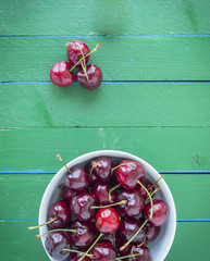 Ripe cherries on a wooden green table.