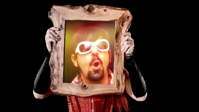 A sexy girl holding a wooden frame with a scene: a crazy DJ making funny faces on the dance floor.
