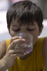 Child drinking a glass of pure water