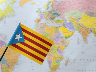 A flag of Catalonia on the background of the world map. 