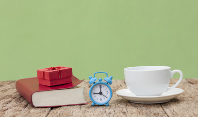 Top wooden table with coffee mug. Gift box and a book