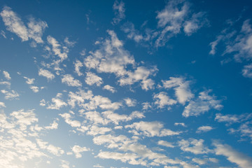 White clouds in a blue sky sky in sunlight in autumn