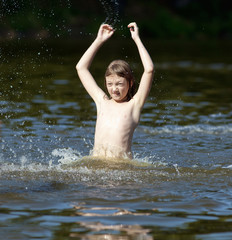 Boy Having Fun Jumping up and Splashing Water
