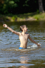 Boy Having Fun Jumping up and Splashing Water