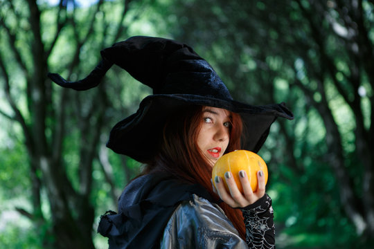 Photo of witch with pumpkin in hand