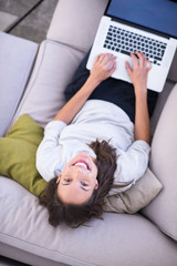 Young woman using laptop at home top view