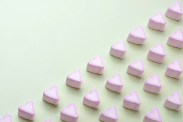 Valentines Day candy hearts marshmallows over green background