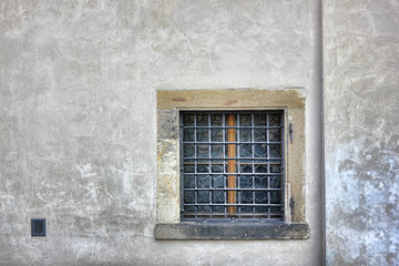 Square Latticed window in gray stone wall.