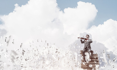 Handsome violinist play his melody and symbols fly around in air