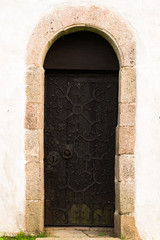 Very old ornamented wooden church door in black.