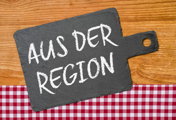  Schiefertafel auf einem rot karierten Tischtuch - Aus der Region