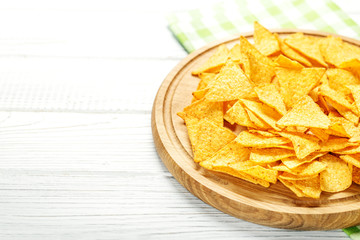 Sharp Mexican Nachos chips on a wooden tray. Concept - bad food, cafe, pub, party.