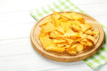 Spicy Mexican Nachos chips on a wooden tray. Concept - bad food,