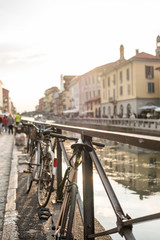 Bicycles parking at the Naviglio Grande with building along the canal in Milan, Italy.