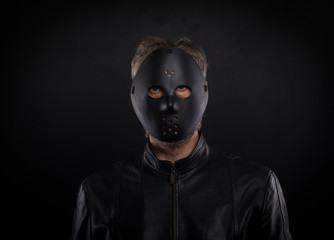 Mystery man holding black  mask. Anonymous social masking concept.