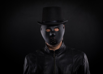 Mystery man holding black  mask. Anonymous social masking concept.