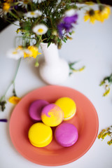 Macaroons and pink flowers tulips on white rustic wooden table with place for text. Present on Mothers day, Valentines Day or Womens day. Gritings woman concept. Copy space.