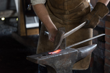 action close up of blacksmith hammering metal