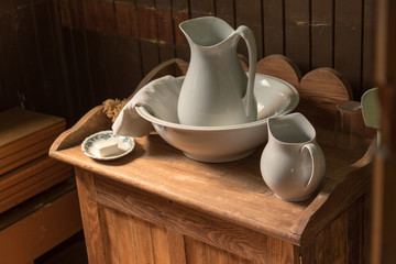 white ceramic water jug and basin on wooden pioneer table