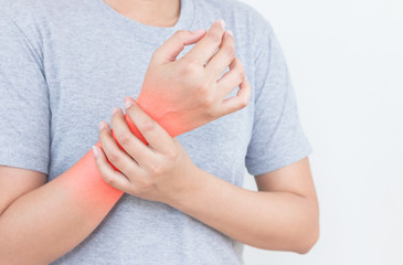 Young woman has pain in wrist on white background.