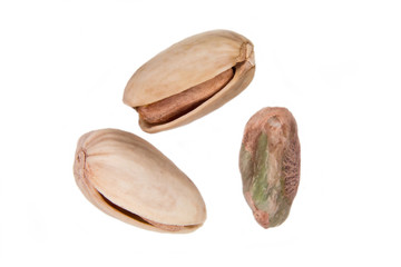 Some pistachios on a white background seen from above