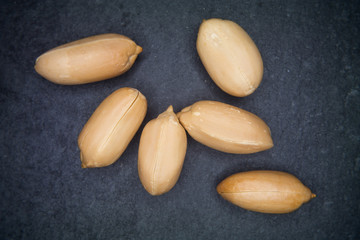 Some peanuts peeled on a slate floor
