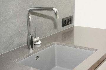 Modern kitchen metal faucet and ceramic kitchen sink.